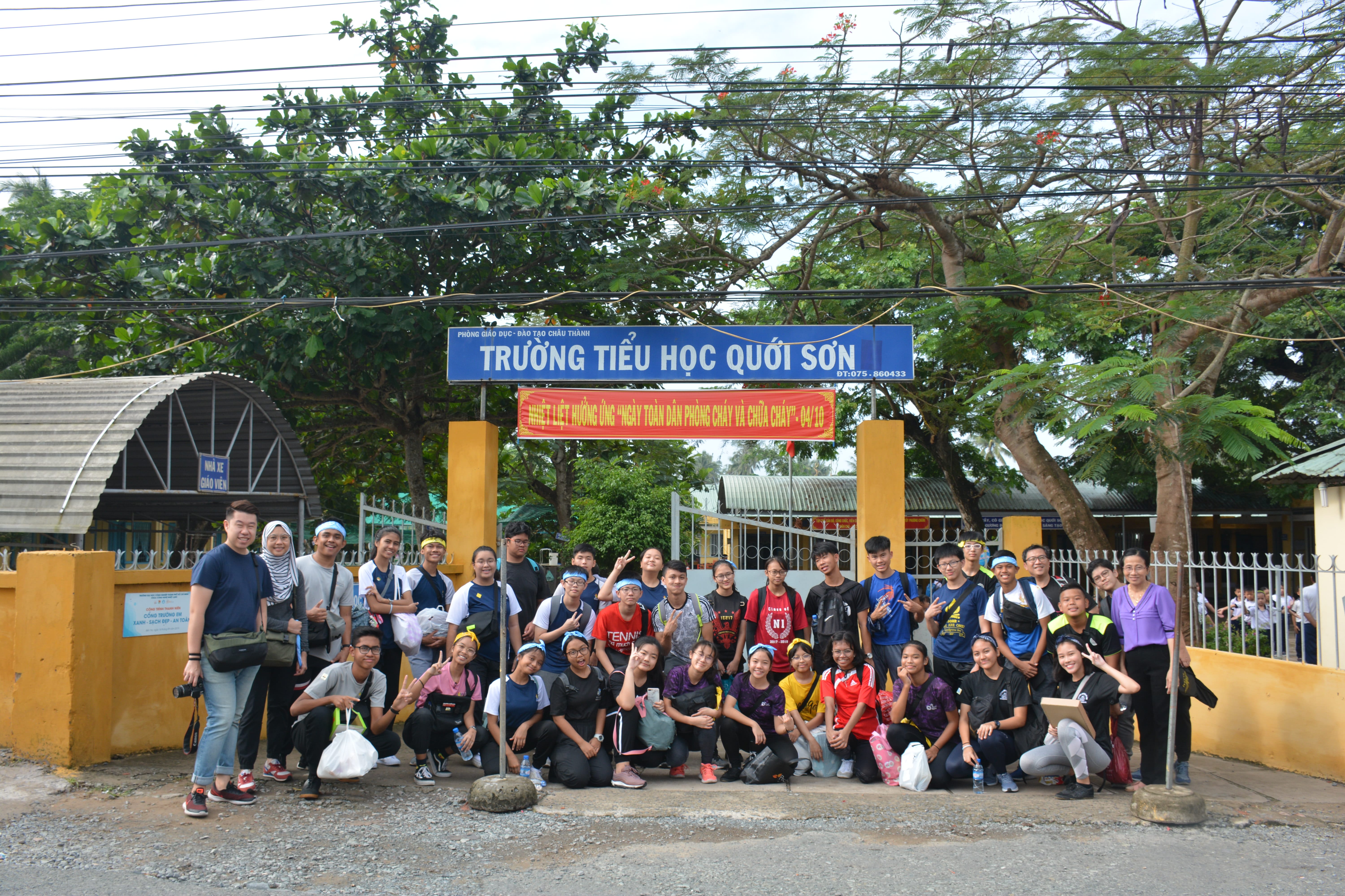 Students posing in front of Quới Sơn Elementary School during their OLJ.